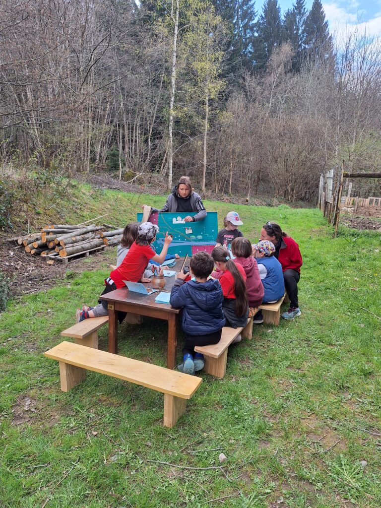 Enfants autour d'une table lors d'un atelier pédagogique à la ferme