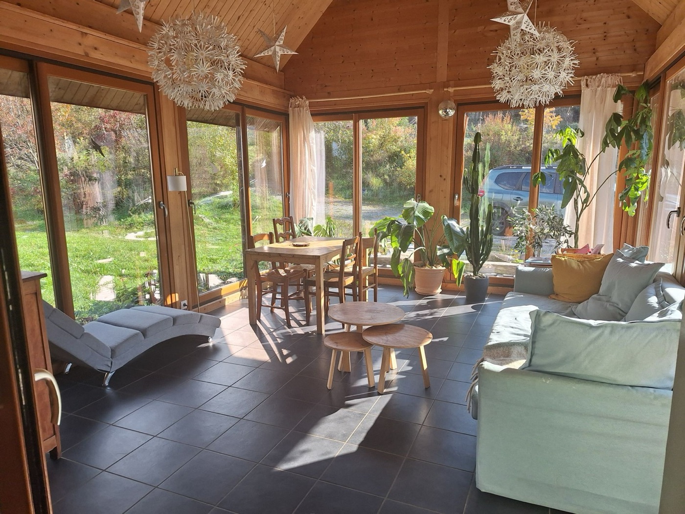 La véranda vitrée du gîte, salon lumineux avec vue sur le jardin